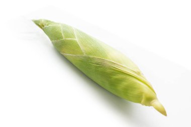 Beyaz arkaplanda çiğ mısırı kapat.