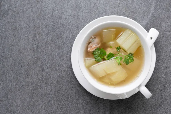 Boiled winter melon soup with chicken rib in white bowl on table