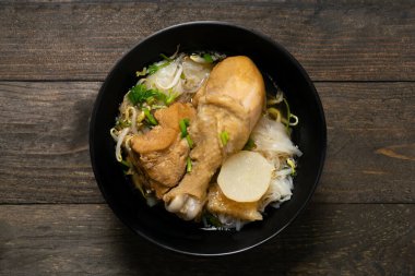 Tavuklu erişte, ahşap masadaki siyah kasede..