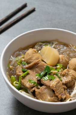 Vermicelli, beton masada beyaz kasede sığır eti..