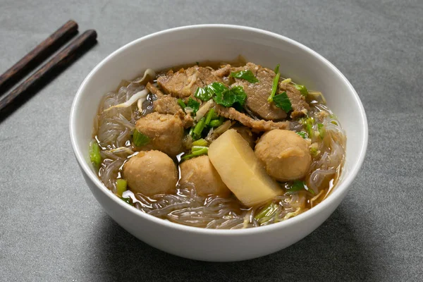 Vermicelli, beton masada beyaz kasede sığır eti..