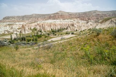 Doğa manzaralı panorama benzersiz kaba taş ve çim dağ manzaralı gökyüzü arka plan, Kapadokya ile kırmızı ve Gül Vadisi