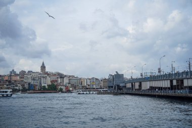 Istanbul, Türkiye - 26 Mayıs 2018: Akşam görünümü Galata Kulesi bölge, binalar, insanlar Balık tutma ile Köprü ve boğaz deniz suyu tekneler, martılar ve bulutlu gökyüzü arka plan, Istanbul