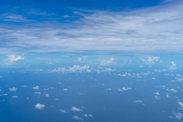 明るく青い空地平線とプーケット飛行飛行機の窓から広大な海海を背景抽象的な白い雲の小さなビュー — ストック写真