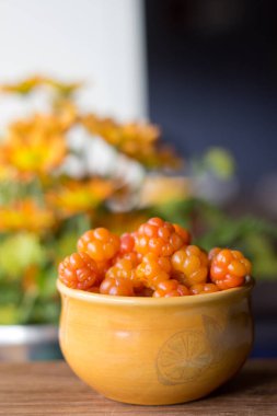 Cloudberry Rubus chamaemorus, ahşap masa üzerinde turuncu kâseye, Norveç 'te sonbahar hasadı Hemsedal kayak merkezi yakınlarında Buskerud, Norveç' te, takvim, poster, duvar kağıdı basmak için fotoğraf