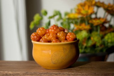 Cloudberry Rubus chamaemorus, ahşap masa üzerinde turuncu kâseye, Norveç 'te sonbahar hasadı Hemsedal kayak merkezi yakınlarında Buskerud, Norveç' te, takvim, poster, duvar kağıdı basmak için fotoğraf