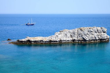 Kayalar ve ufukta yüzen gemi denize sıfır güzel görünümüne. Akdeniz denize yakın Lindos City, Yunanistan