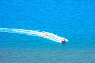 denizin üzerinde tüp çekerek bir teknenin görünümü
