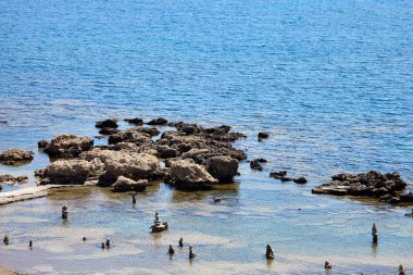Yaz aylarında güneşli sahilde mavi deniz suyunda taş çakıl piramit