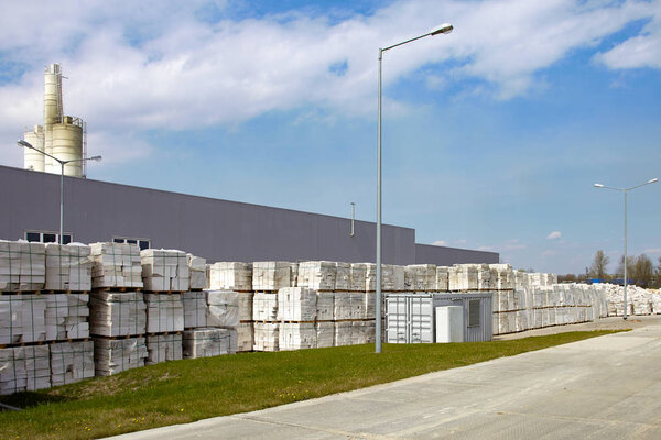 Defective aerated concrete blocks on pallets in front of factory