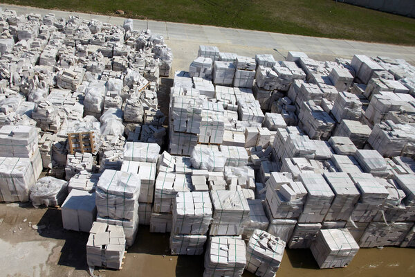 Aerial view of autoclaved aerated concrete blocks, both defective and good, on pallets, stored at factory warehouse