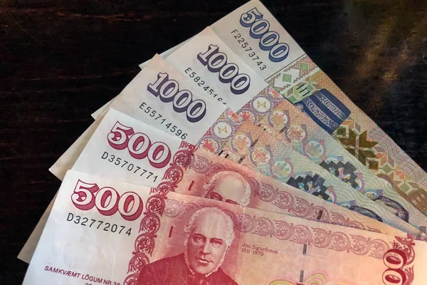 İzlanda parası. İzlanda'nın parası. Ahşap masa üzerinde birkaç İzlanda kronu faturaları. İzlanda Kronu İzlanda 'nın ulusal para birimidir (kronur)