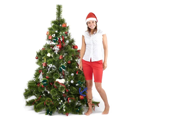 Schöne Frau mit Weihnachtsmütze, die den Weihnachtsbaum schmückt, isoliert auf weiß — Stockfoto