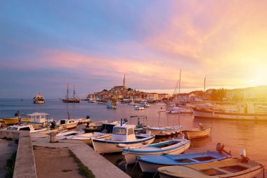 Rovinj, Hırvatistan 'ın eski kostal kasabası altın gündoğumu ışığında. Motorlu tekneler, tekneler ve Rovinj limanında su yatlar. Aziz Euphemia Kilisesi yüksek kule. Istra bölgesi, popüler turistik destinasyon.