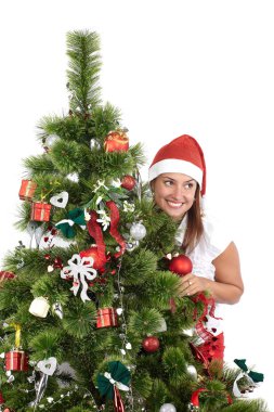 Santa Cap güzel gülümseyen kadın, Noel ağacının arkasında, beyaz izole