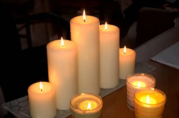 Velas ardientes sobre una mesa de madera sobre un fondo oscuro — Foto de Stock