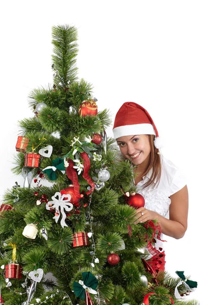 Mulher sorridente bonita em Santa cap, atrás da árvore de Natal, isolado em branco — Fotografia de Stock