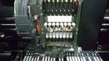 Otomatik bileşen yükleyici. Elektronik devre kartı üretimi. Robot montaj için elektronik parçalar ve çipler kuruyor. Robot kol. Kırmızı ışık. Yüksek teknoloji..