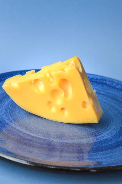 Queso Amarillo Con Agujeros Plato Fondo Azul —  Fotos de Stock