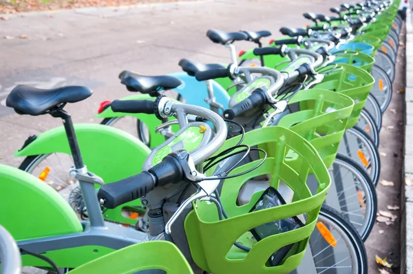 Parking with a large number of electric bikes for renting and driving around the city. Autumn sunny day. Close-up