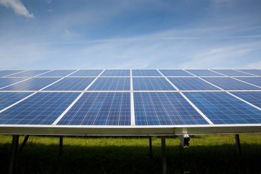 Güneşli gökyüzü olan güneş panelleri. Mavi güneş panelleri. yenilenebilir enerji için fotovoltaik modüllerin arkaplanı.