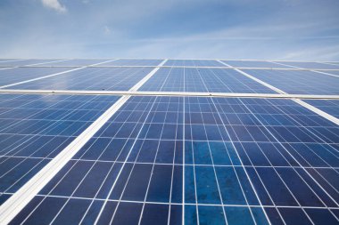 Güneşli gökyüzü olan güneş panelleri. Mavi güneş panelleri. yenilenebilir enerji için fotovoltaik modüllerin arkaplanı.