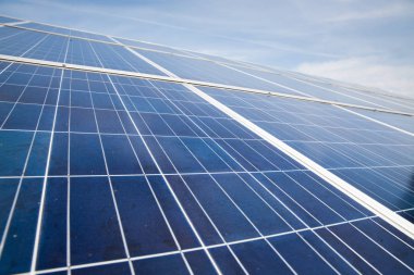 Güneşli gökyüzü olan güneş panelleri. Mavi güneş panelleri. yenilenebilir enerji için fotovoltaik modüllerin arkaplanı.