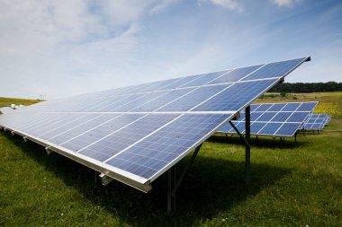 Güneşli gökyüzü olan güneş panelleri. Mavi güneş panelleri. yenilenebilir enerji için fotovoltaik modüllerin arkaplanı.