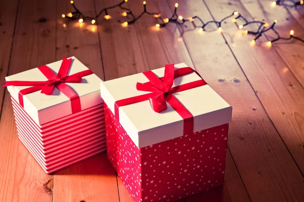 Rote Geschenkboxen Und Weihnachtsbeleuchtung Auf Holzboden — Stockfoto