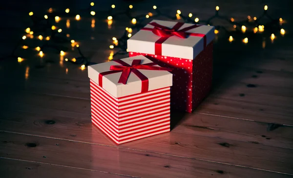 Rote Geschenkboxen Und Weihnachtsbeleuchtung Auf Holzboden — Stockfoto