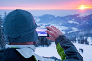 adam alarak resim Sunrise karla kaplı çam ağaçları içinde