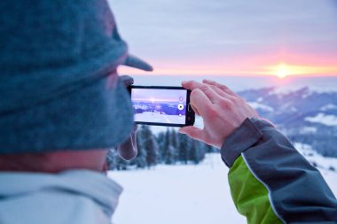 adam alarak resim Sunrise karla kaplı çam ağaçları içinde