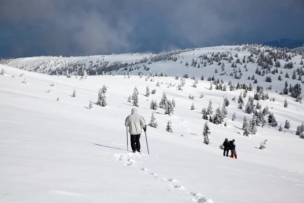 雪の降る冬の山でのトレッキング — ストック写真
