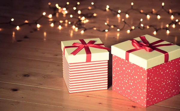 Rote Geschenkboxen Und Weihnachtsbeleuchtung Auf Holzboden — Stockfoto