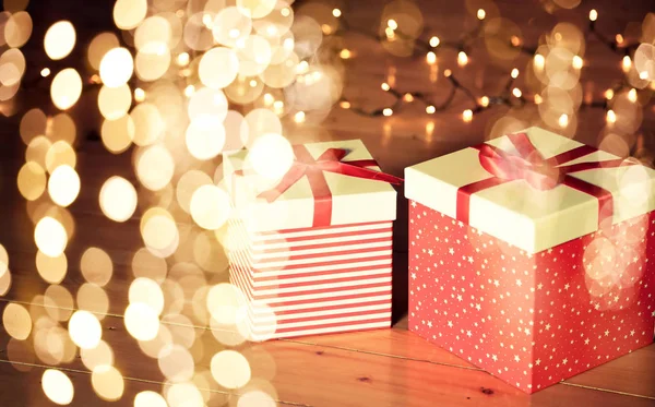 Rote Geschenkboxen Und Weihnachtsbeleuchtung Auf Holzboden — Stockfoto