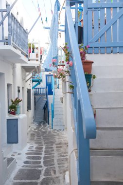 Mykonos 'un geleneksel dar sokaklarında mavi kapılar ve beyaz duvarlar