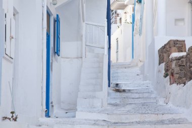 Mykonos 'un geleneksel dar sokaklarında mavi kapılar ve beyaz duvarlar