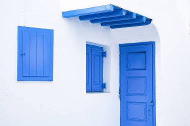 Mykonos 'un geleneksel dar sokaklarında mavi kapılar ve beyaz duvarlar