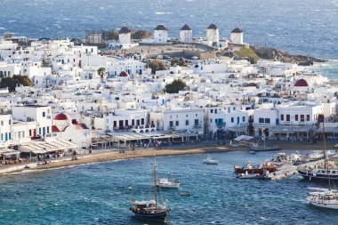 Güneşli bir yaz gününde, Mykonos, Cyclades, Yunanistan 'ın Mykonos kasabasının ünlü yel değirmenleriyle panoramik manzarası