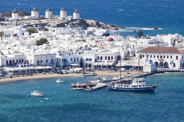 Güneşli bir yaz gününde, Mykonos, Cyclades, Yunanistan 'ın Mykonos kasabasının ünlü yel değirmenleriyle panoramik manzarası
