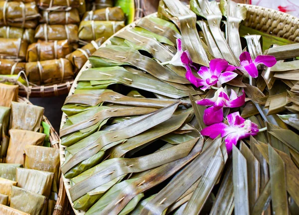 food wrapped in bamboo leaves on the market