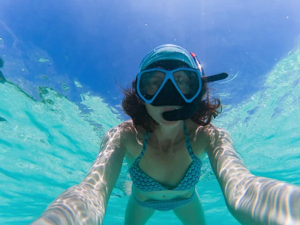 Женщина делает подводное селфи во время плавания с маской и трубкой в кристалле CL — стоковое фото