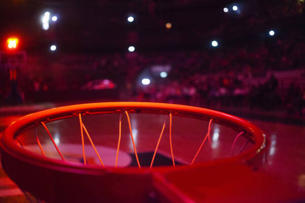 basketball hoop in red neon lights in sports arena during game