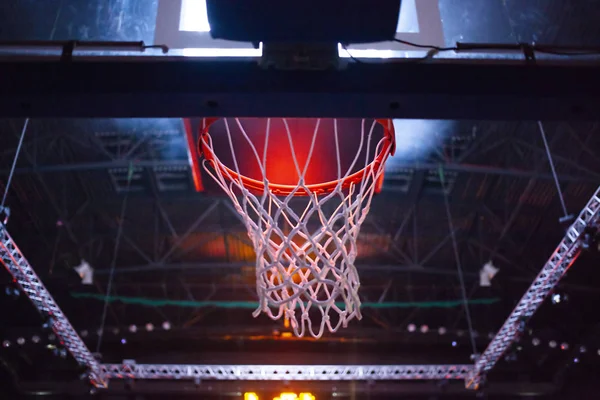 Баскетбольний кільце в червоному неоновому вогні на спортивній арені під час гри — стокове фото