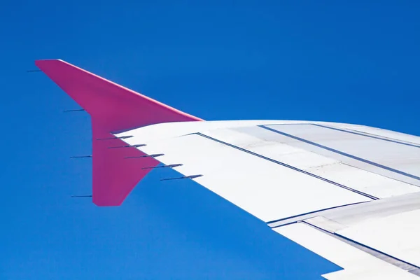 Asas de avião rosa no céu azul - conceito de liberdade e viagem — Fotografia de Stock