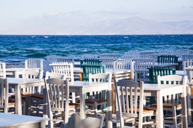 Lokanta sandalyeleri ve deniz kenarındaki masalar