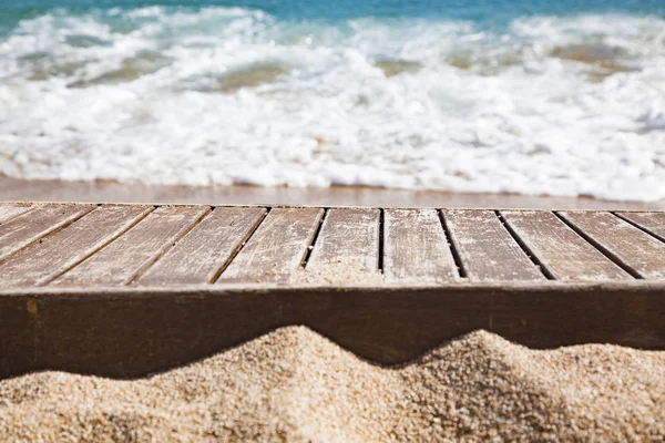Tablón de madera en arena y mar azul en el fondo —  Fotos de Stock