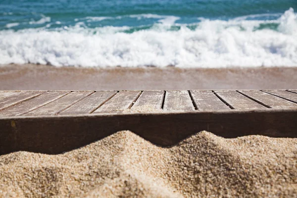 Tablón de madera en arena y mar azul en el fondo — Foto de Stock