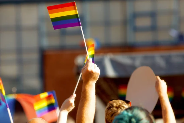 Comunidade de orgulho em um desfile com as mãos levantadas e a bandeira LGBT — Fotografia de Stock