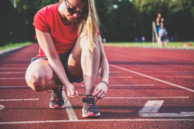 Koşu pistindeki genç bir kadın Bağcıklı ayakkabılar